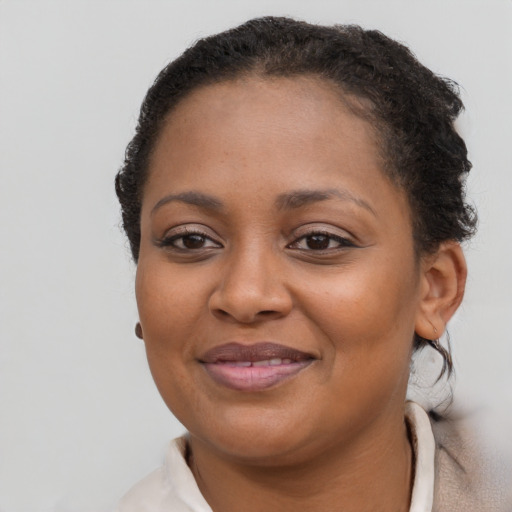 Joyful black young-adult female with short  brown hair and brown eyes