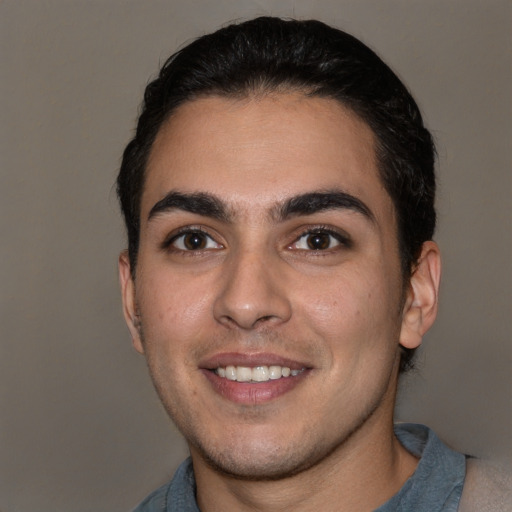 Joyful white young-adult male with short  black hair and brown eyes