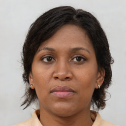 Joyful black adult female with medium  brown hair and brown eyes