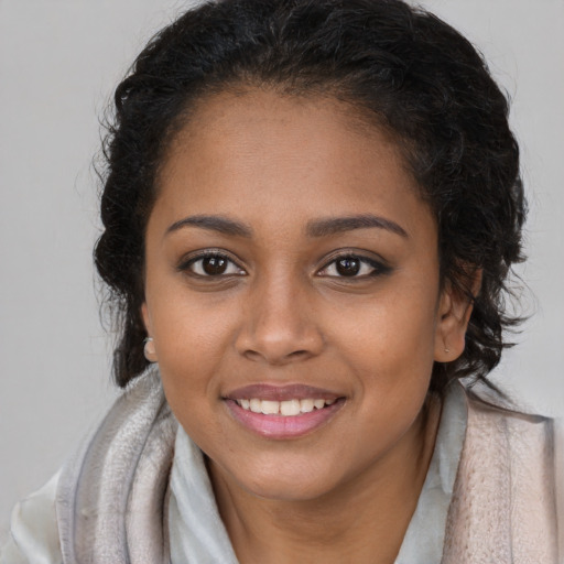 Joyful black young-adult female with long  brown hair and brown eyes