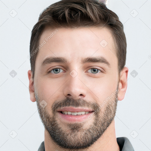 Joyful white young-adult male with short  brown hair and grey eyes