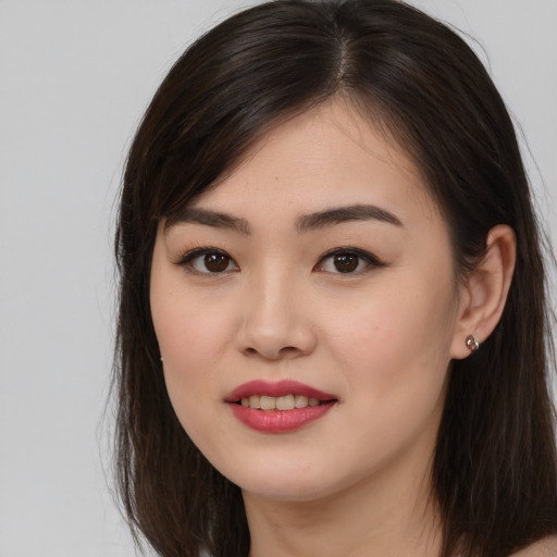 Joyful asian young-adult female with long  brown hair and brown eyes