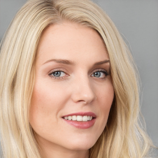 Joyful white young-adult female with long  blond hair and blue eyes