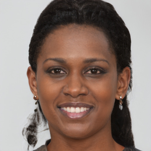 Joyful black young-adult female with medium  brown hair and brown eyes
