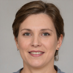 Joyful white adult female with medium  brown hair and grey eyes