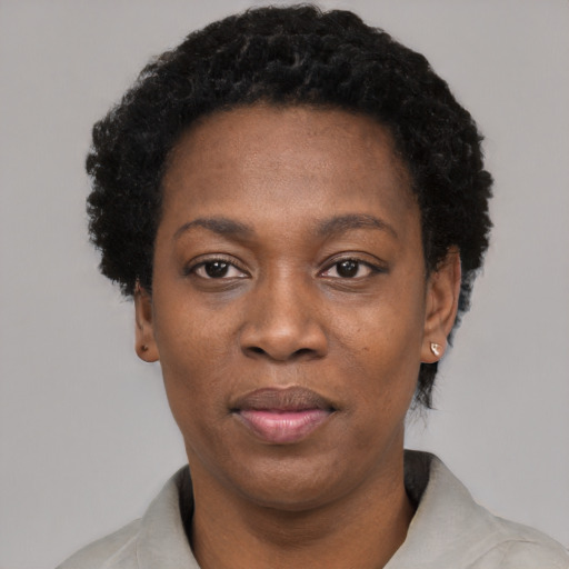 Joyful black adult female with short  black hair and brown eyes
