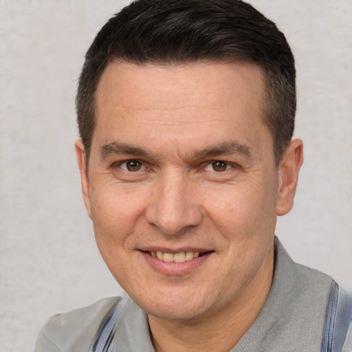 Joyful white adult male with short  brown hair and brown eyes