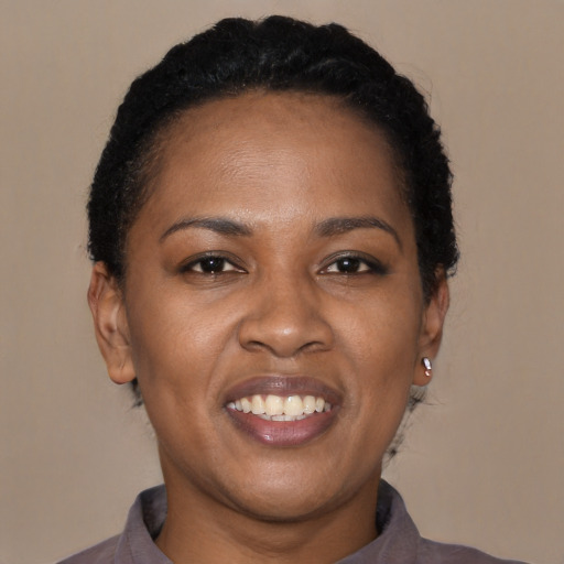Joyful black young-adult female with short  black hair and brown eyes