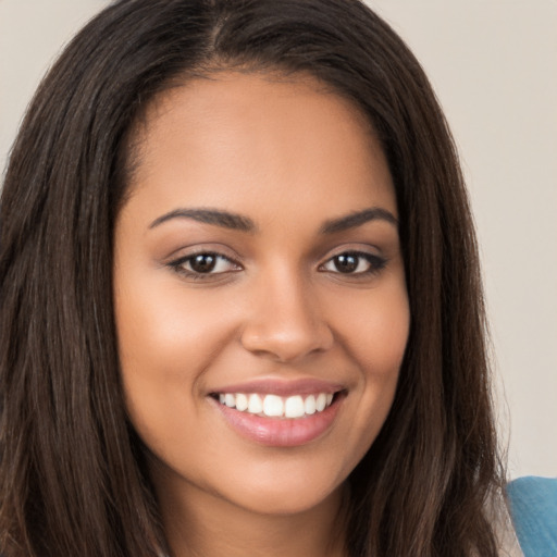 Joyful latino young-adult female with long  brown hair and brown eyes