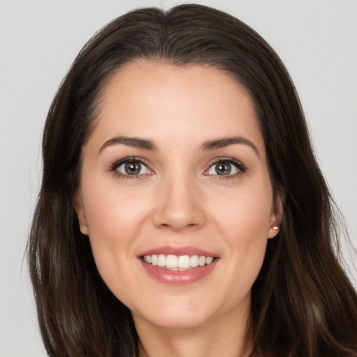 Joyful white young-adult female with long  brown hair and brown eyes