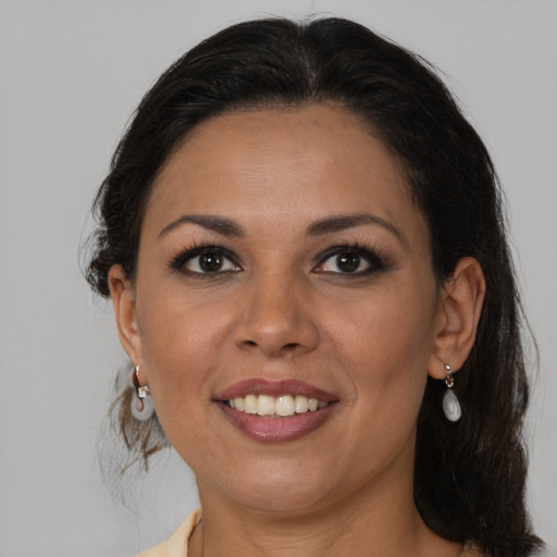 Joyful latino adult female with medium  brown hair and brown eyes