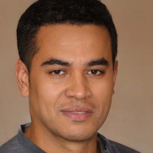 Joyful latino young-adult male with short  brown hair and brown eyes