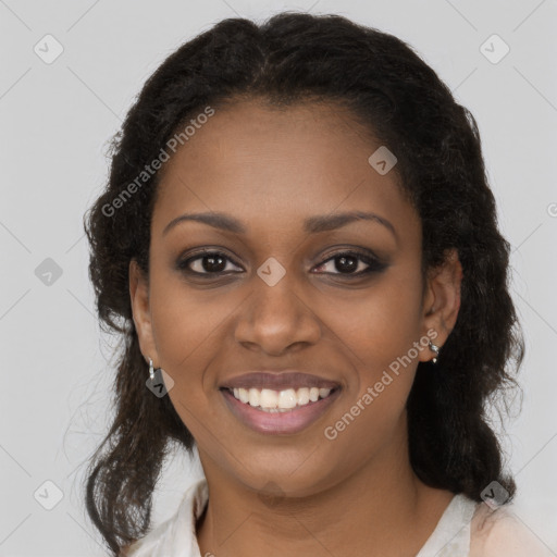 Joyful black young-adult female with long  brown hair and brown eyes