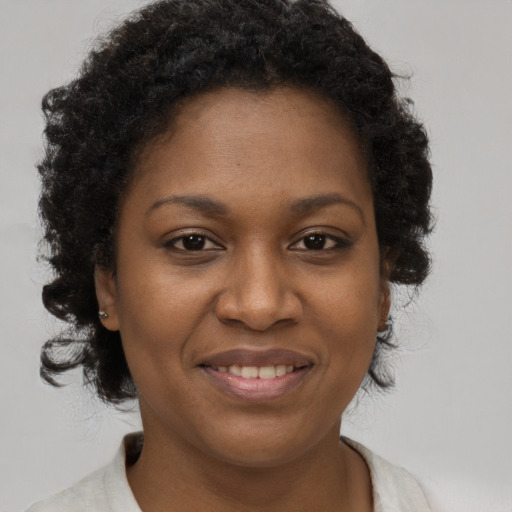 Joyful black adult female with short  brown hair and brown eyes