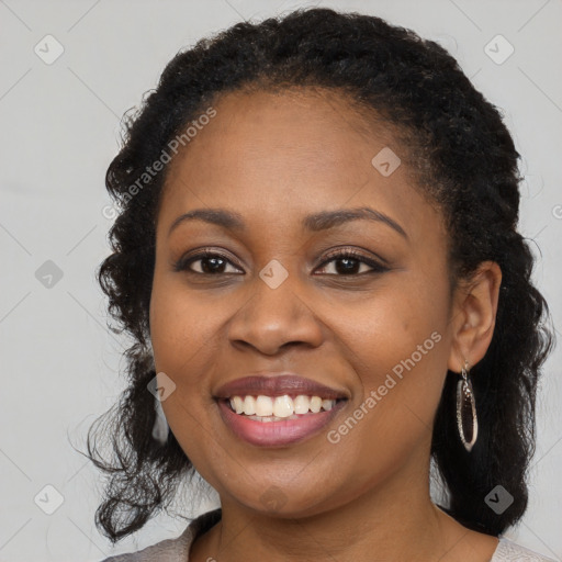 Joyful black young-adult female with long  brown hair and brown eyes