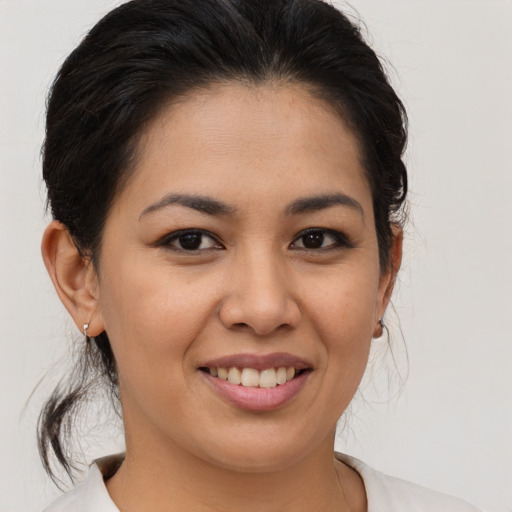 Joyful latino young-adult female with medium  brown hair and brown eyes