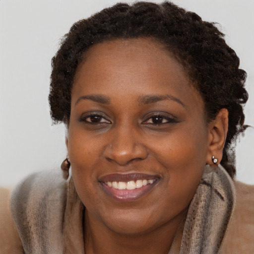 Joyful black adult female with short  brown hair and brown eyes