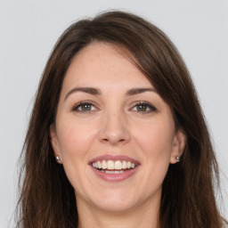 Joyful white young-adult female with long  brown hair and grey eyes