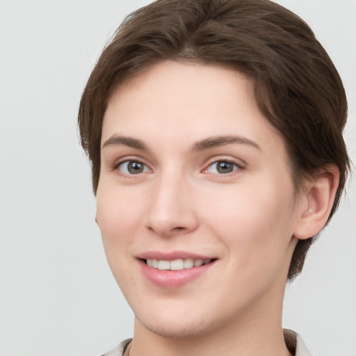 Joyful white young-adult female with short  brown hair and grey eyes