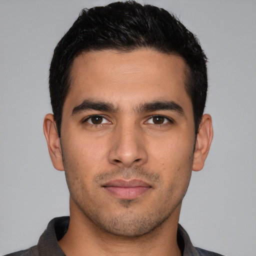 Joyful white young-adult male with short  black hair and brown eyes