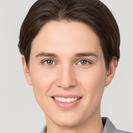 Joyful white young-adult female with short  brown hair and grey eyes