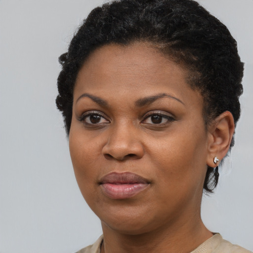 Joyful black young-adult female with short  black hair and brown eyes