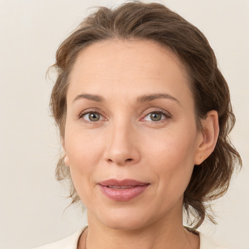 Joyful white adult female with medium  brown hair and grey eyes