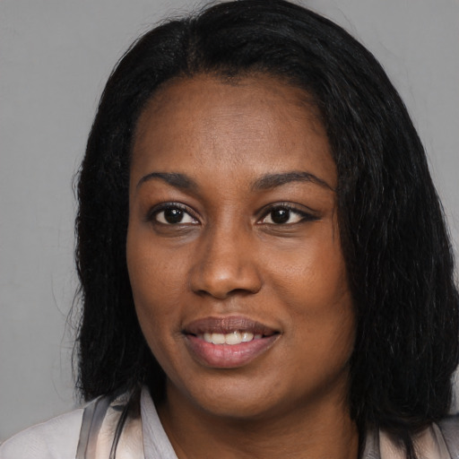Joyful black young-adult female with long  black hair and brown eyes