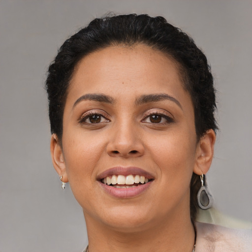 Joyful latino young-adult female with short  black hair and brown eyes