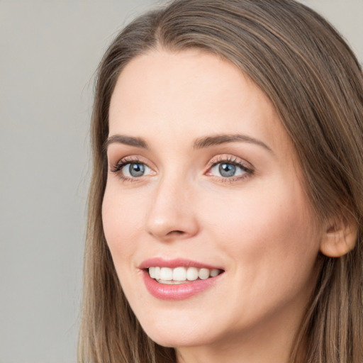 Joyful white young-adult female with long  brown hair and grey eyes