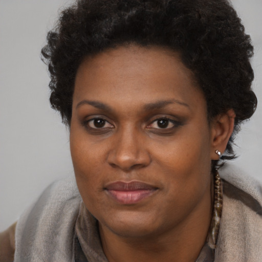 Joyful black adult female with short  brown hair and brown eyes