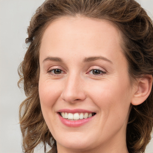 Joyful white young-adult female with medium  brown hair and green eyes