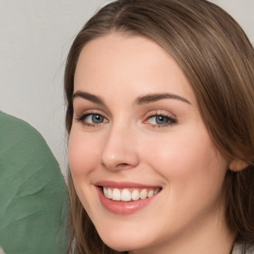 Joyful white young-adult female with long  brown hair and green eyes