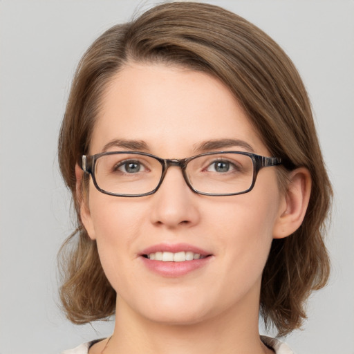 Joyful white young-adult female with medium  brown hair and green eyes