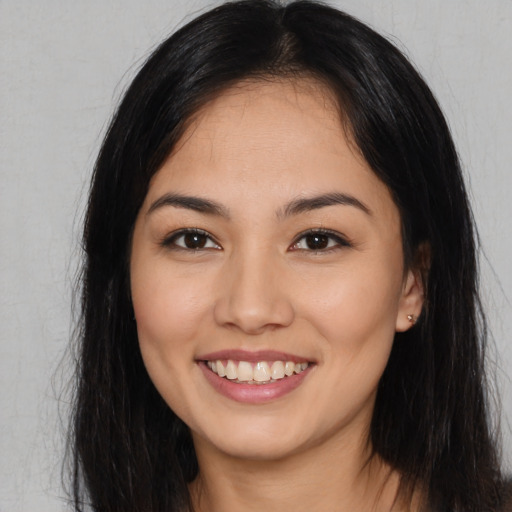 Joyful asian young-adult female with long  black hair and brown eyes