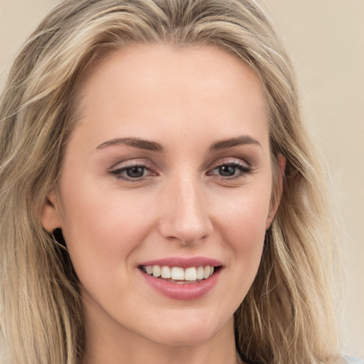 Joyful white young-adult female with long  brown hair and blue eyes