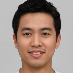 Joyful asian young-adult male with short  black hair and brown eyes