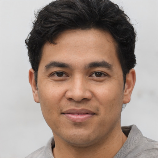 Joyful asian young-adult male with short  brown hair and brown eyes
