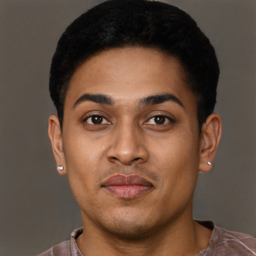 Joyful black young-adult male with short  brown hair and brown eyes