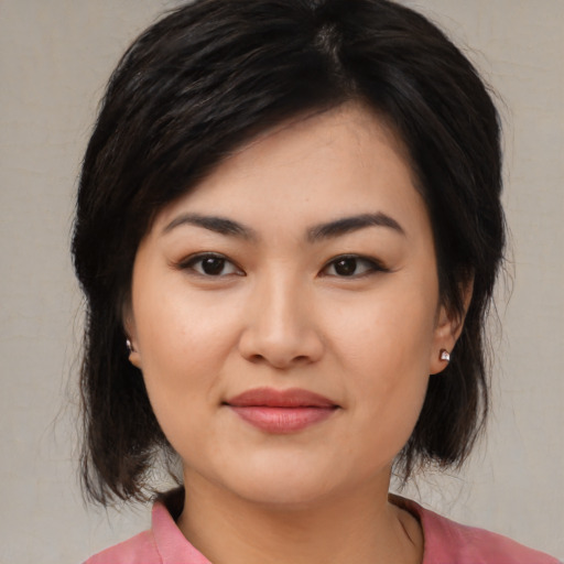 Joyful asian young-adult female with medium  brown hair and brown eyes