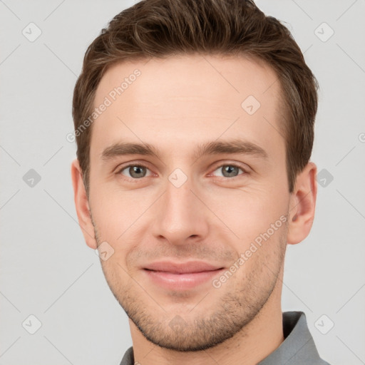 Joyful white young-adult male with short  brown hair and grey eyes