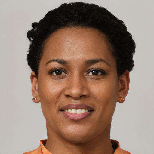 Joyful latino young-adult female with short  black hair and brown eyes