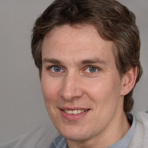 Joyful white adult male with short  brown hair and grey eyes