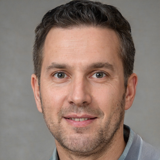 Joyful white adult male with short  brown hair and brown eyes