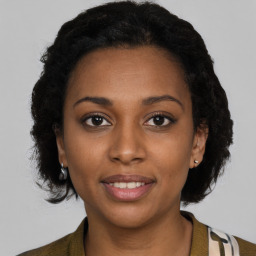 Joyful black young-adult female with short  brown hair and brown eyes