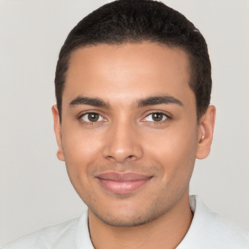 Joyful latino young-adult male with short  brown hair and brown eyes