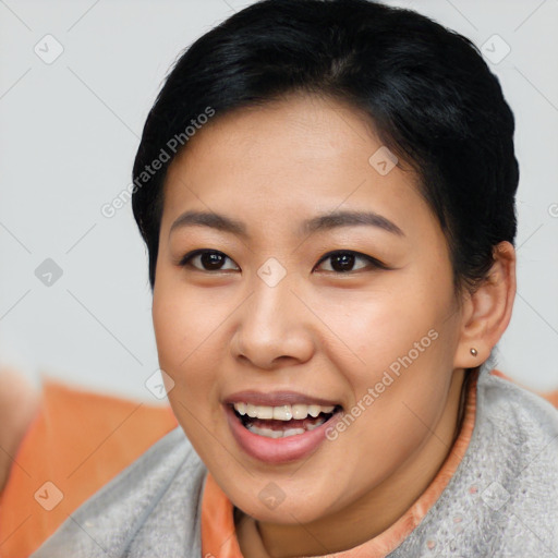 Joyful asian young-adult female with short  black hair and brown eyes