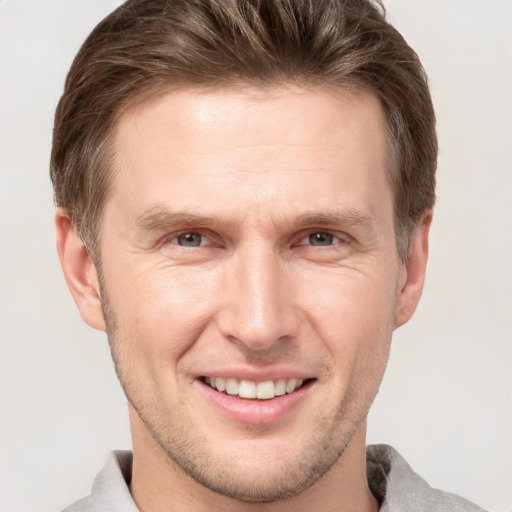 Joyful white adult male with short  brown hair and grey eyes