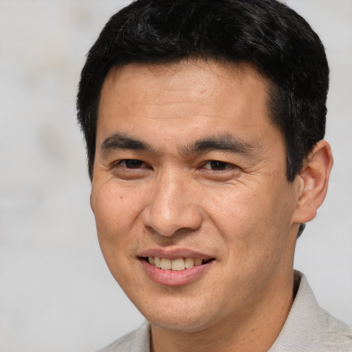Joyful white adult male with short  black hair and brown eyes