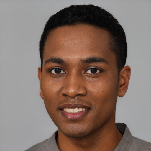 Joyful black young-adult male with short  black hair and brown eyes
